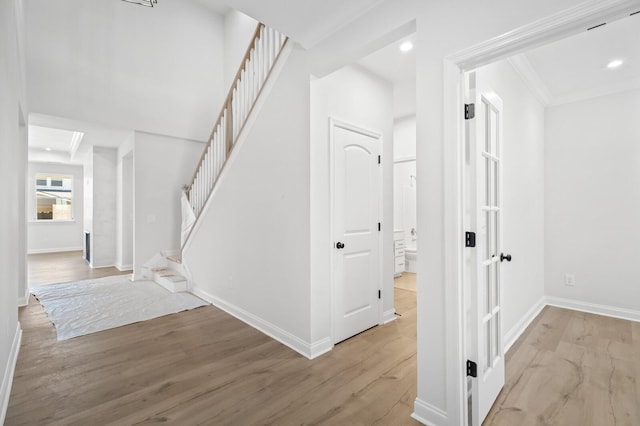 corridor featuring crown molding, recessed lighting, light wood-style flooring, and baseboards