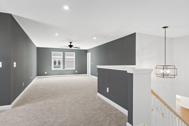 empty room with recessed lighting, ceiling fan with notable chandelier, baseboards, and light colored carpet