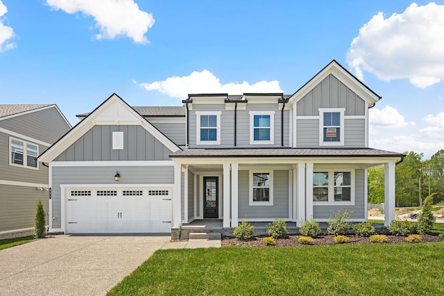 view of front facade featuring driveway, covered porch, a front lawn, and board and batten siding