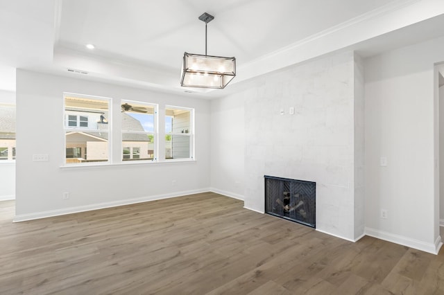 unfurnished living room featuring a wealth of natural light, a fireplace, baseboards, and wood finished floors