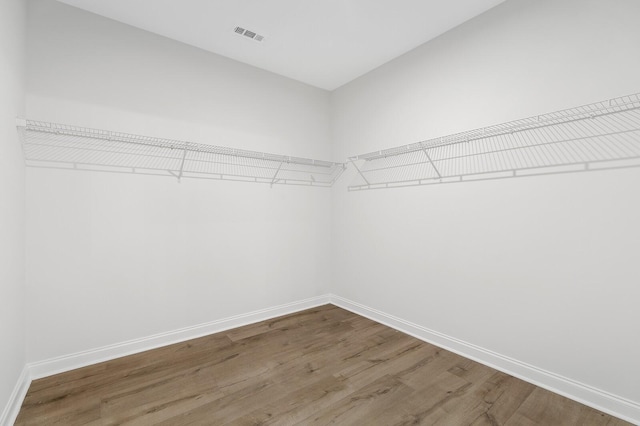 walk in closet with visible vents and wood finished floors