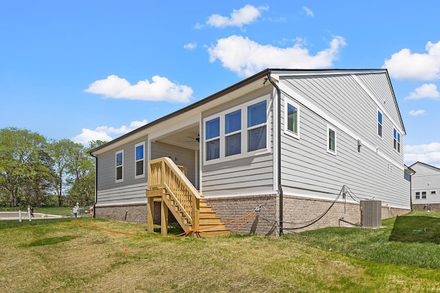 back of property featuring stairway, a lawn, cooling unit, and a ceiling fan