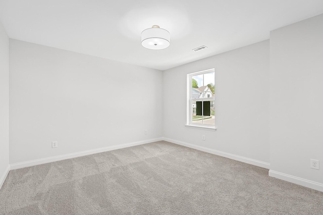 spare room with light carpet, baseboards, and visible vents