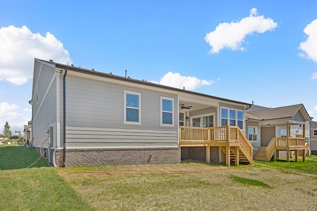 rear view of house with a deck, a yard, stairway, and ceiling fan