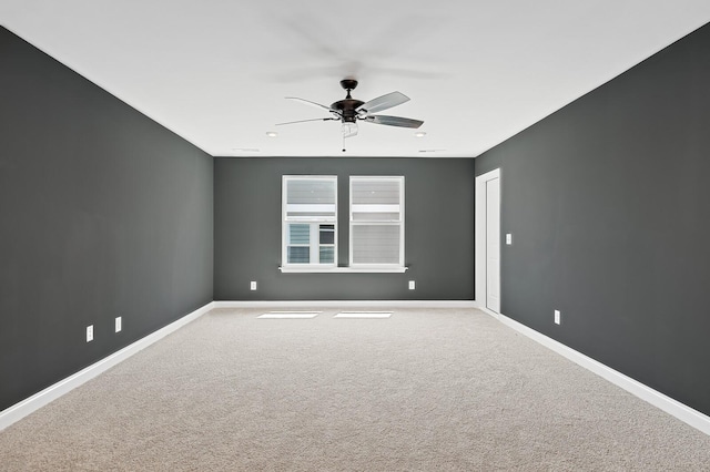 spare room featuring carpet flooring, ceiling fan, and baseboards