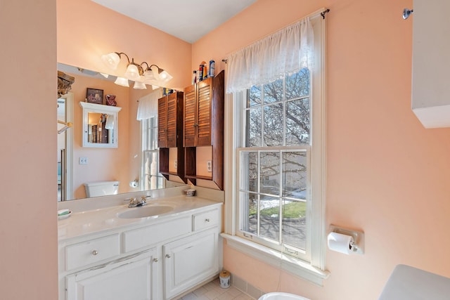 bathroom with vanity, toilet, and a healthy amount of sunlight