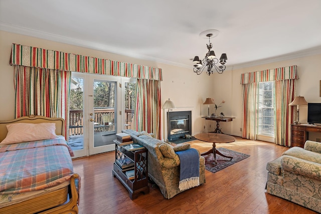 interior space featuring a glass covered fireplace, wood finished floors, and crown molding