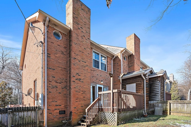 rear view of property featuring crawl space, a chimney, fence, and brick siding