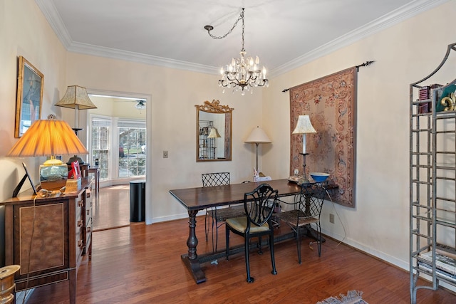 dining area featuring a notable chandelier, crown molding, baseboards, and wood finished floors