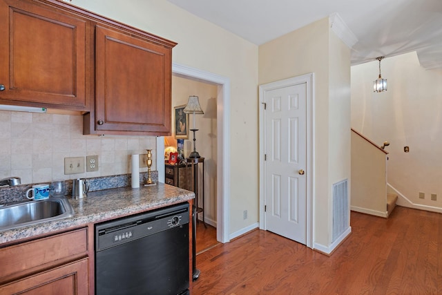 kitchen with black dishwasher, visible vents, wood finished floors, a sink, and backsplash