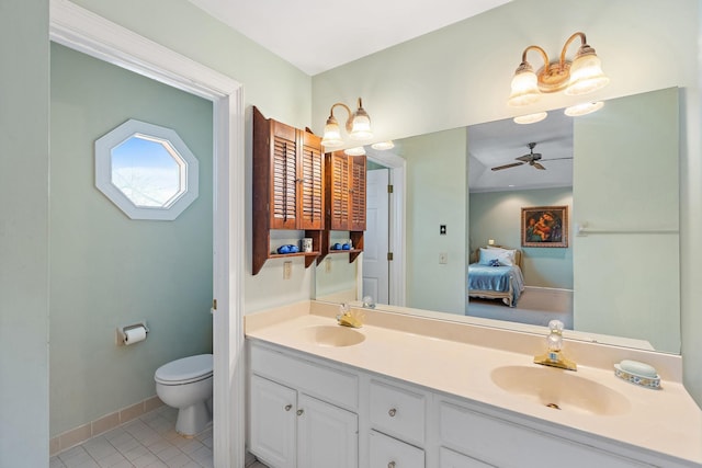 ensuite bathroom featuring double vanity, toilet, connected bathroom, a sink, and tile patterned floors