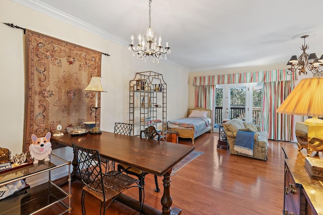 dining area featuring an inviting chandelier, ornamental molding, and wood finished floors