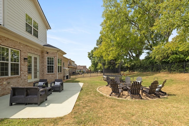 view of yard featuring a fenced backyard, a trampoline, a patio, and french doors