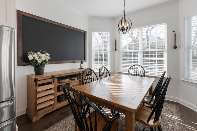 dining room featuring a chandelier, baseboards, dark wood finished floors, and crown molding