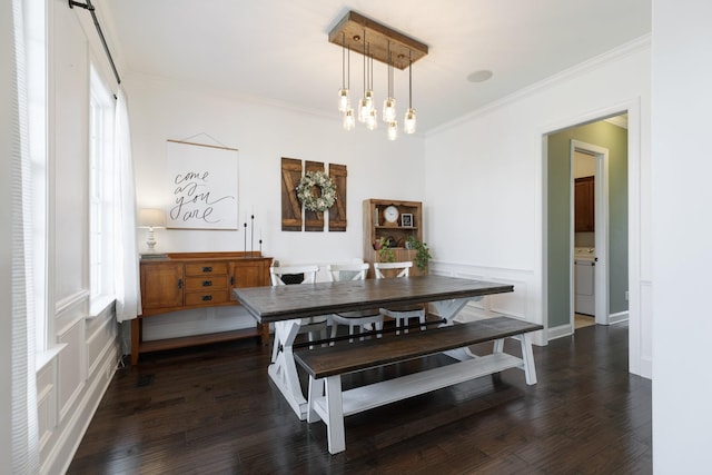 dining room with washer / dryer, dark wood-type flooring, ornamental molding, and a notable chandelier