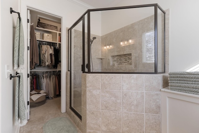 bathroom featuring a spacious closet and a stall shower