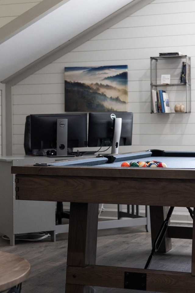 rec room featuring wood walls, vaulted ceiling, and wood finished floors