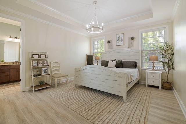 bedroom featuring light wood-type flooring, a notable chandelier, a tray ceiling, and crown molding