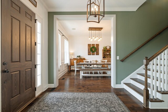 foyer entrance with stairway, ornamental molding, and a notable chandelier