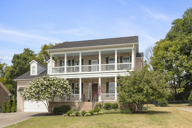 view of front of home featuring driveway, a garage, a porch, a front lawn, and brick siding