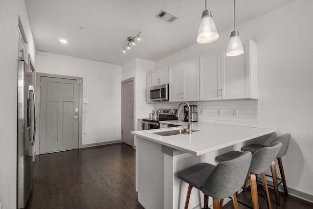 kitchen with a sink, visible vents, stainless steel appliances, and decorative backsplash