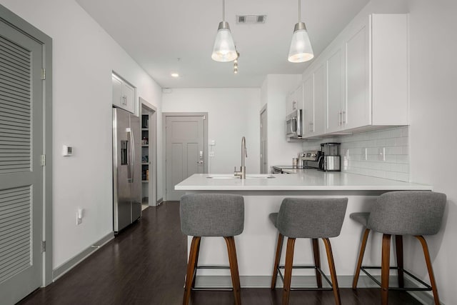 kitchen with a peninsula, visible vents, appliances with stainless steel finishes, and white cabinets