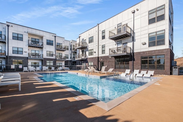 pool with a patio area and fence