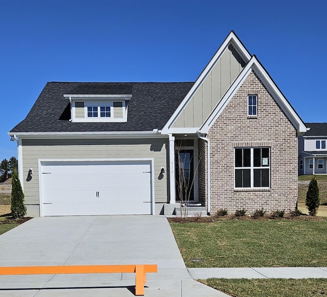 view of front of home featuring a garage, brick siding, concrete driveway, a front lawn, and board and batten siding