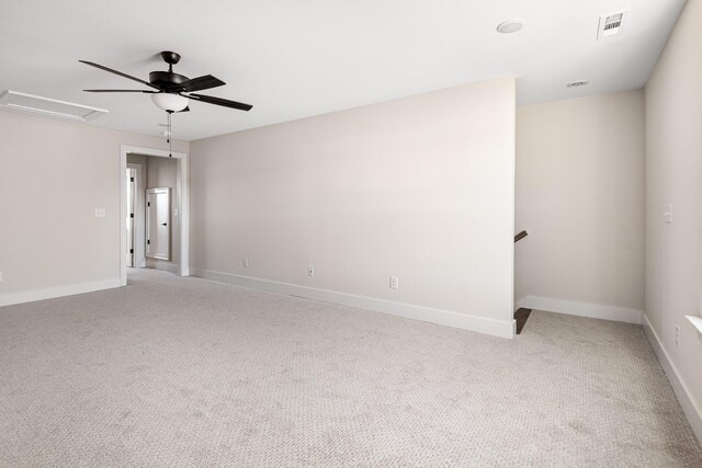 spare room with light carpet, visible vents, baseboards, and a ceiling fan