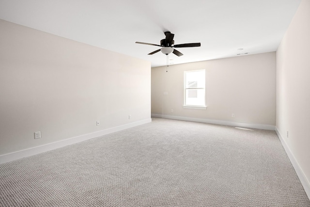 empty room featuring light carpet, ceiling fan, and baseboards