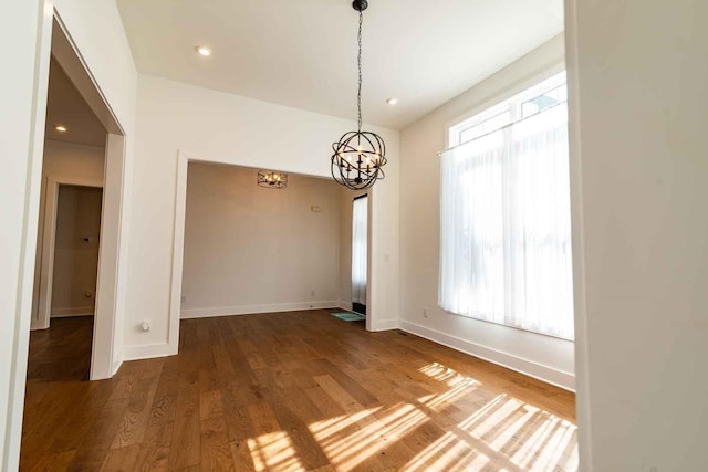 unfurnished room featuring an inviting chandelier, baseboards, wood finished floors, and recessed lighting