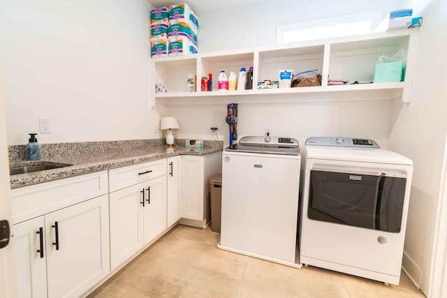 clothes washing area with washer and dryer, cabinet space, a sink, and light tile patterned floors