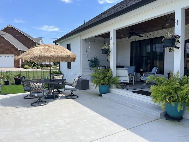 view of patio with a ceiling fan, outdoor dining area, and fence