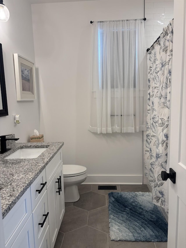 full bathroom with visible vents, toilet, vanity, tile patterned flooring, and baseboards