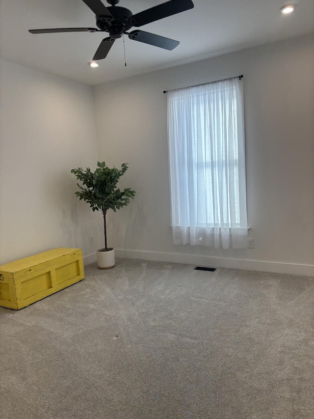 carpeted empty room with baseboards, visible vents, and recessed lighting