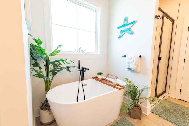 bathroom featuring a freestanding tub and a shower stall