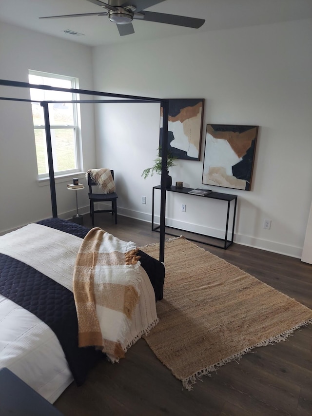 bedroom with ceiling fan, baseboards, and dark wood-type flooring