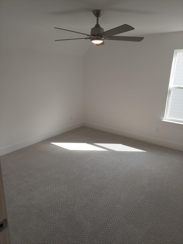 spare room with ceiling fan, carpet floors, and baseboards