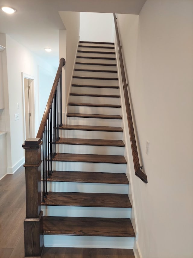 staircase featuring recessed lighting, baseboards, and wood finished floors