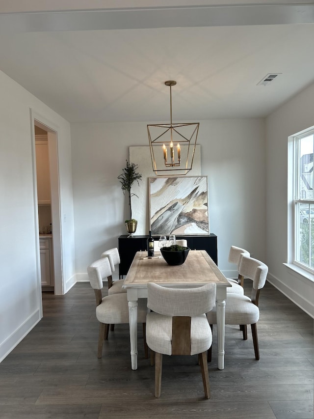 dining space featuring baseboards, visible vents, dark wood finished floors, and a notable chandelier