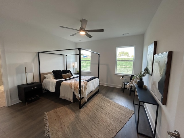 bedroom with ceiling fan, visible vents, dark wood finished floors, and baseboards