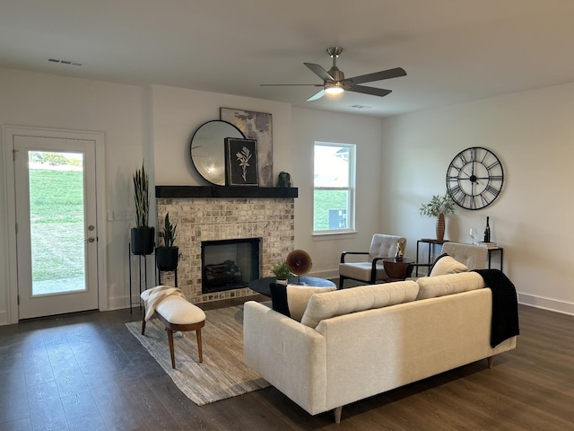 living area featuring a wealth of natural light, dark wood-type flooring, and visible vents