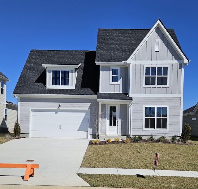 modern farmhouse style home featuring board and batten siding, a front yard, roof with shingles, and driveway