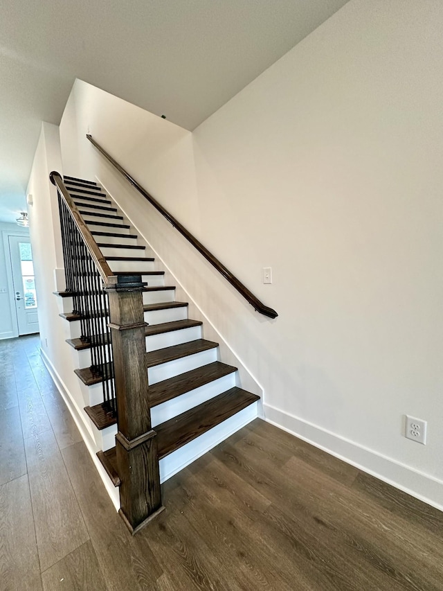 staircase with wood finished floors and baseboards