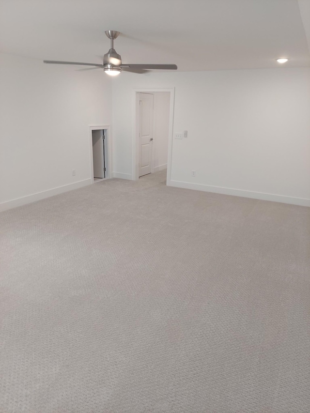 empty room with baseboards, ceiling fan, recessed lighting, and light colored carpet