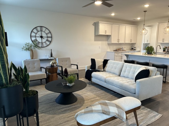 living room featuring recessed lighting, dark wood-style flooring, ceiling fan, and baseboards