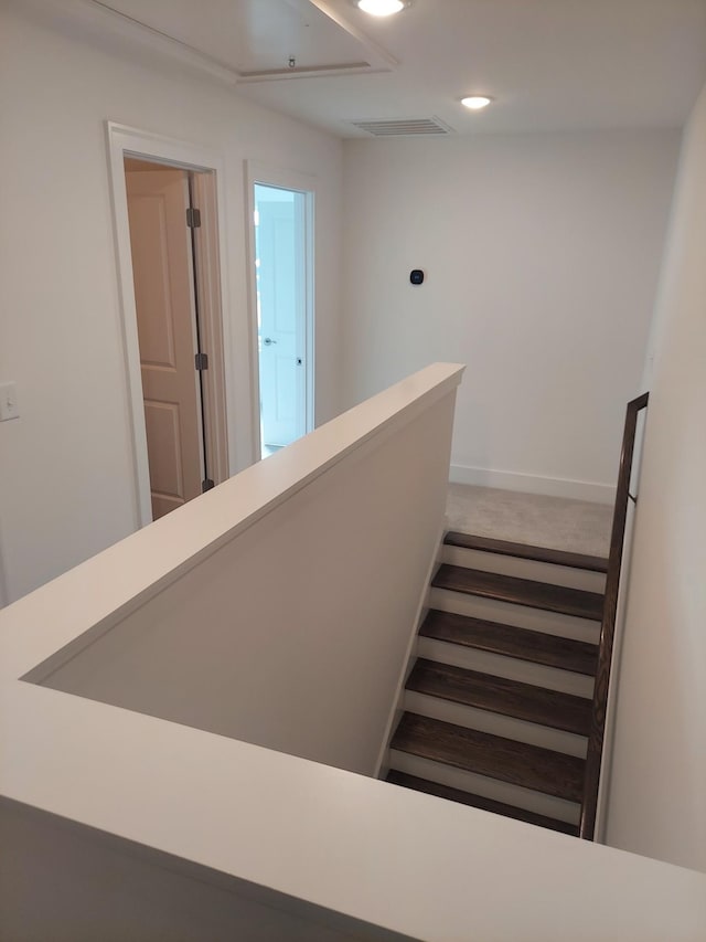 stairway featuring baseboards, visible vents, carpet flooring, and recessed lighting