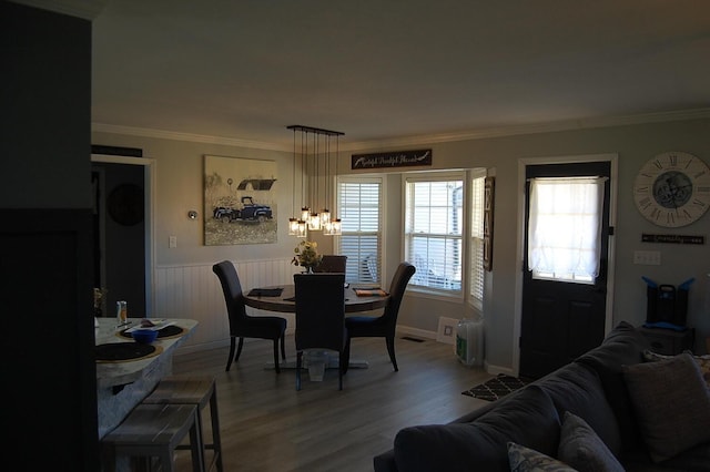 dining room featuring ornamental molding, a wainscoted wall, and wood finished floors