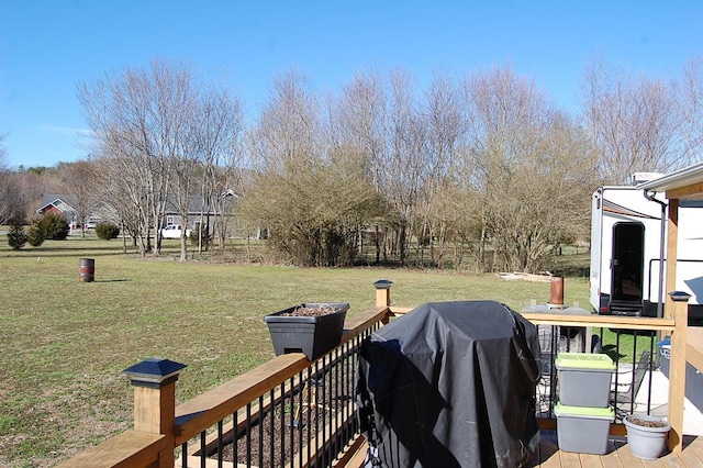 wooden deck featuring a lawn and grilling area