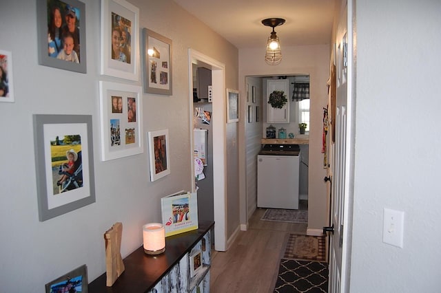 hall featuring wood finished floors and washer / dryer